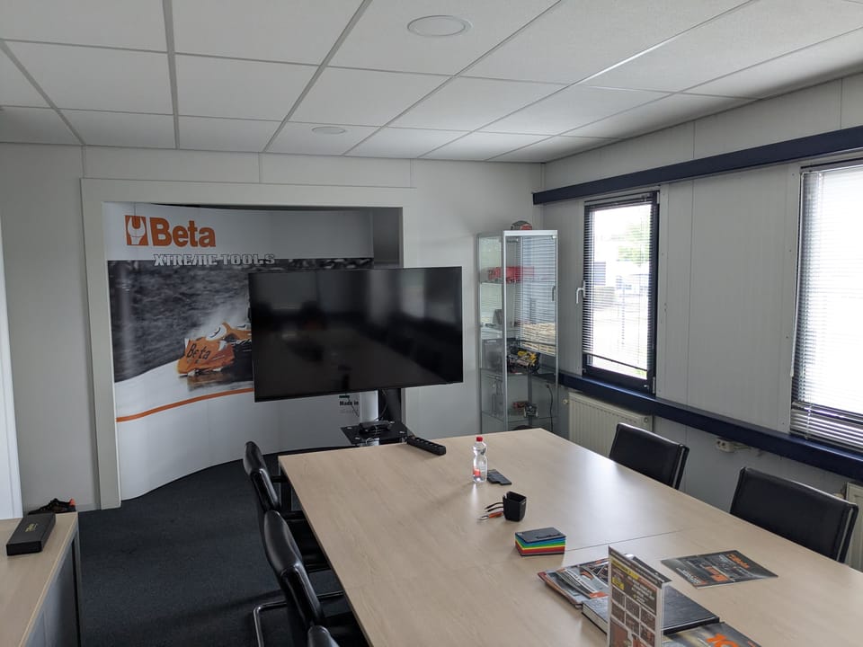 Vergaderruimte met grote tafel en presentatiescherm